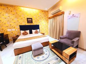 a bedroom with a bed and a chair and a desk at Buddha Heritage in Patna +30 photos