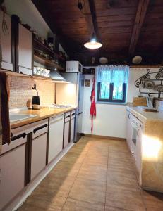 a kitchen with white cabinets and a tile floor at Charming Stone House Dobrinj in Dobrinj +12 photos