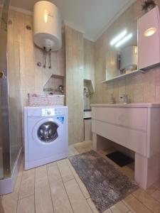 a bathroom with a washing machine and a sink at Charming Stone House Dobrinj in Dobrinj