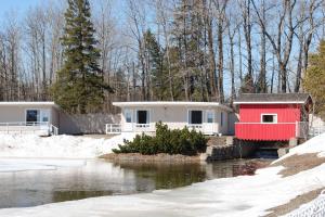 a home with a red house in the snow at Rodeway Inn in Grand Falls