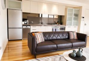 a living room with a leather couch in a kitchen at Rooftops on HenryCentre of West End Cafes in Fremantle