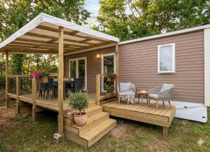 a cabin with a deck with a table and chairs at Cottage 4 personnes in Mirepoix