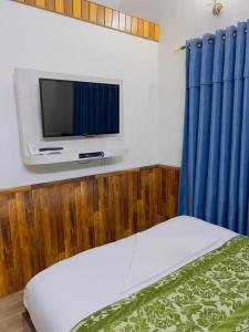 a bedroom with a bed and a tv on a wall at Hotel Mirana Pvt Ltd in Kathmandu