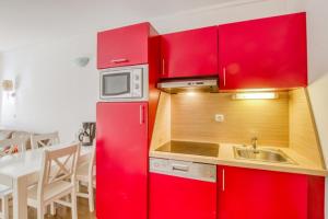 a red kitchen with a sink and a microwave at Flat With Swimming Pool Near The Beach in Sanary-sur-Mer +16 photos