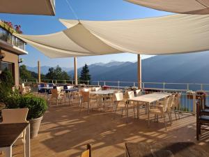 a patio with tables and chairs with mountains in the background at Nouveau Mirabeau in Bellagio +11 photos