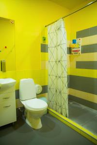 a yellow bathroom with a toilet and a shower at City Hostel Shymkent in Shymkent +34 photos