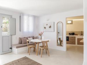 a white living room with a table and a couch at myMykonos Guest House in Platis Gialos