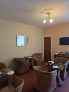 a dining room with tables and wicker chairs at Beeches Guest House in Dyce +30 photos