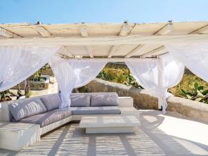 a patio with a couch under a pergola at myMykonos Guest House in Platis Gialos