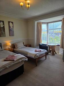 a bedroom with two beds and a window at Beeches Guest House in Dyce