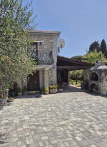 a house with a stone driveway in front of a building at Charming Stone House Dobrinj in Dobrinj
