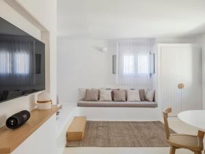 a white living room with a couch and a table at myMykonos Guest House in Platis Gialos