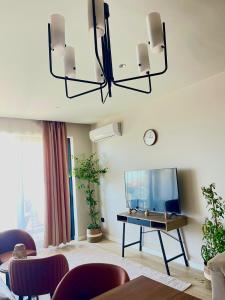 a living room with a table and a television at SeaBreeze Resort Baku Apartment Studio in Baku