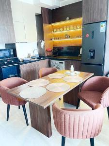 a kitchen with a wooden table and pink chairs at SeaBreeze Resort Baku Apartment Studio in Baku