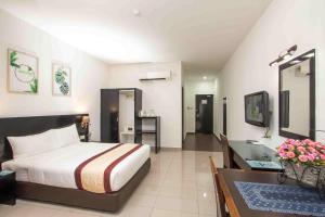 a bedroom with a bed and a desk and a sink at Swan Garden Hotel in Pasir Gudang