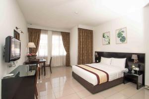 a hotel room with a bed and a television at Swan Garden Hotel in Pasir Gudang