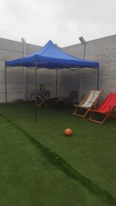 a blue tent with two chairs and an orange ball on the grass at Tampu Machi Eco Camping in Chancayllo