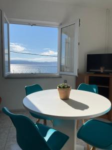 a room with a table and chairs and a window at Apartman Grospic in Cesarica