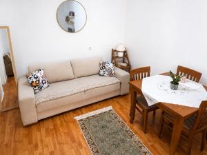 a living room with a couch and a table at Cozy Apartment, Free Parking near Dajti Cable Car, Bunk'Art in Tirana