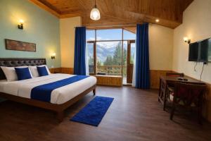 a bedroom with a bed and a large window at 4 Bedroom Luxury Bungalow In Manali With Beautiful Scenic Mountain & Orchard View - #Private Bungalow #Premium Big rooms #Parking #Guest Preferred in Manāli