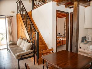 a living room with a table and a staircase at Iron House in Agios Georgios