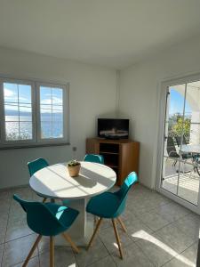 a dining room with a white table and chairs at Apartman Grospic in Cesarica