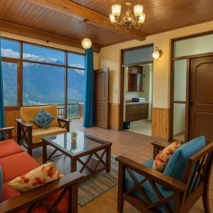 a living room with a couch and a table at 4 Bedroom Luxury Bungalow In Manali With Beautiful Scenic Mountain & Orchard View - #Private Bungalow #Premium Big rooms #Parking #Guest Preferred in Manāli +27 photos