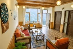 a living room with a dart board on the wall at 4 Bedroom Luxury Bungalow In Manali With Beautiful Scenic Mountain & Orchard View - #Private Bungalow #Premium Big rooms #Parking #Guest Preferred in Manāli