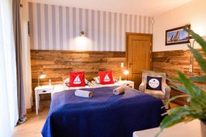 a bedroom with a blue bed with red pillows at Ostoja Dwa Jeziora in Węgorzewo