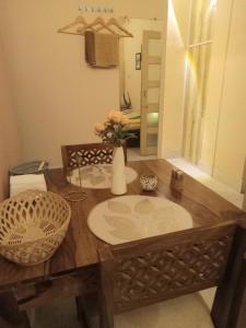 a wooden table with a vase of flowers on it at Beautiful 1-bed Apartment-Suite Kolkata near Airport in Kolkata +25 photos