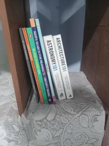a group of books sitting in a box at Beautiful 1-bed Apartment-Suite Kolkata near Airport in Kolkata