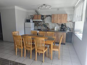 a kitchen with a wooden dining table and chairs at Vormsi Ohvitseride Maja korter nr 3 in Hullo +6 photos