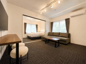 a living room with a couch and a bed at Hotel ONE'S RESIDENCE in Sapporo