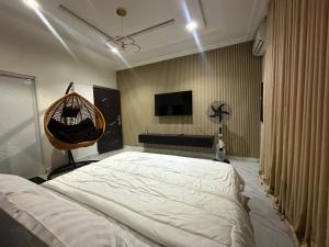 a bedroom with a large white bed and a television at Cozy 2 Bedroom Apartment - Lugbe in Rubuchi