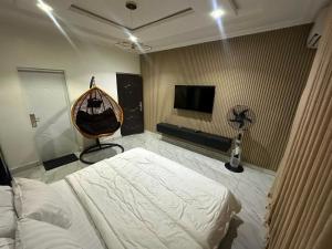 a bedroom with a bed and a flat screen tv at Cozy 2 Bedroom Apartment - Lugbe in Rubuchi
