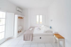 a white bedroom with a bed and a window at ALMA THERA Boutique Hotel in Perissa