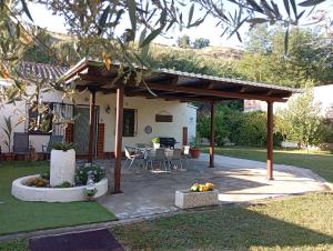 a pergola with a table and chairs in a yard at Cortijo Batán in Dúdar