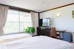 a bedroom with a bed and a desk and a window at REIBA STYLE Hotel in Nagasawa