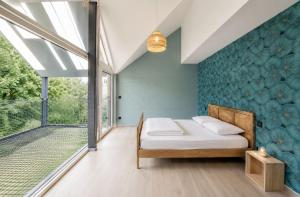 a bedroom with a bed with a blue wall at Au pachî d'Emile in Bièvre