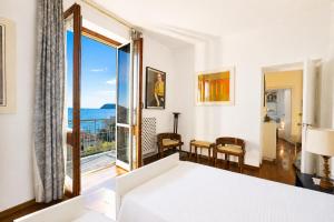 a bedroom with a bed and a view of the ocean at Hostdomus - Villa Gabriella with private pool in Alassio +37 photos