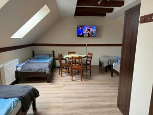 a room with two beds and a table and chairs at Agroturystyka Struzka in Strużka