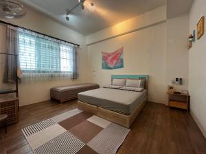 a bedroom with a bed and a couch in it at Come Home Travel in Tainan
