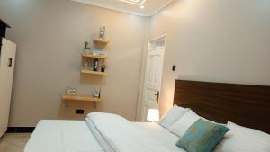 a bedroom with a large white bed with a wooden headboard at Dephil stays in Jinja