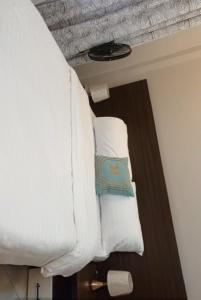 a bed in a room with white sheets and pillows at Dephil stays in Jinja