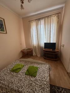 a bedroom with a bed with two green pillows on it at Apollon in Mukacheve