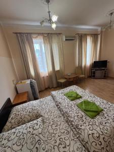 a bedroom with a large bed with green napkins on it at Apollon in Mukacheve