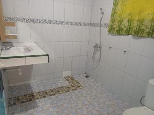 a bathroom with a toilet and a sink and a shower at Lekjon Cottage in Tuktuk Siadong