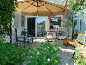 a patio with an umbrella and a table and chairs at B&B Hestia's Hideaway in Kalívia Thorikoú +27 photos