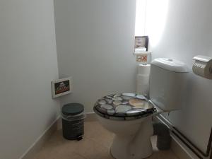 a bathroom with a toilet with a decorated seat at B&B Hestia's Hideaway in Kalívia Thorikoú