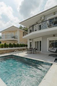 a villa with a swimming pool in front of a house at Diamanti Villa, Pool & Barbecue in Skala Potamias